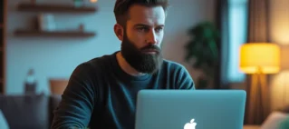 Homem vendo um boleto em seu computador, simbolizando o golpe do falso boleto de acordo judicial ou dívida.