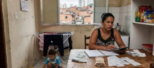 Mãe organizando finanças em casa, ilustrando a busca por pensão alimentícia para o filho mesmo morando sob o mesmo teto.